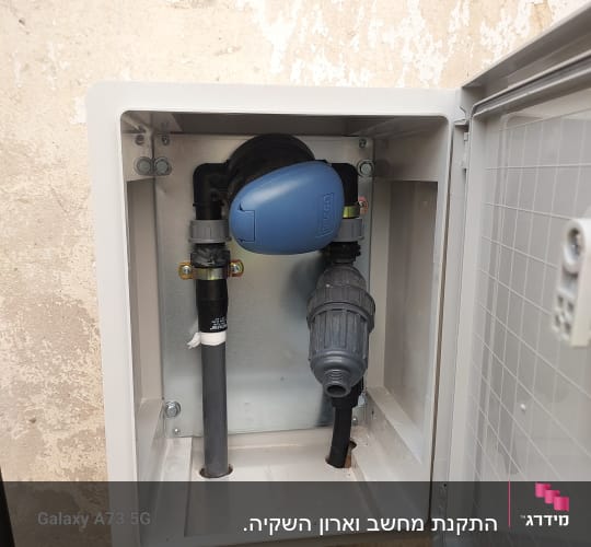 מערכת השקיה עם צינורות ומחברים בארון פתוח
